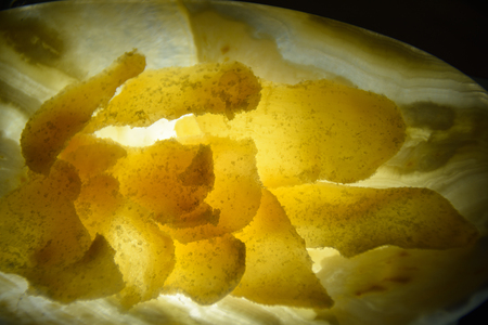 thin ginger slices in yellow light, on the plateの写真素材