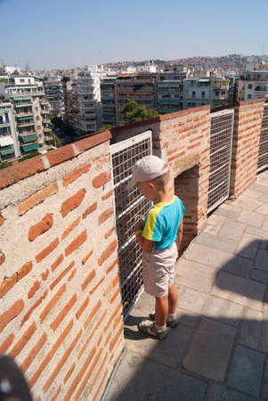 The boy in the tower in Thessaloniki looking down to the street belowの写真素材