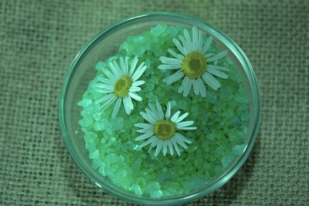 small bowl of green spa salt with flowers, green tonedの写真素材