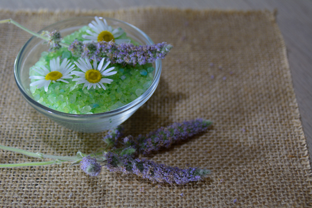 Glass bowl of camomile salt with live flowersの写真素材
