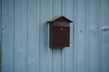metal post box on the corrugated fenceの写真素材