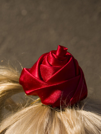 child's ponytail with a red roseの写真素材