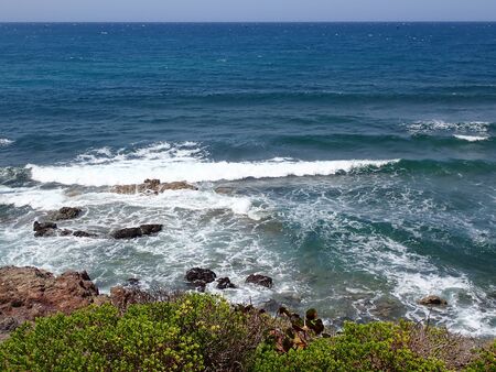 part of the shore, with rocks and waves, in good weatherの写真素材