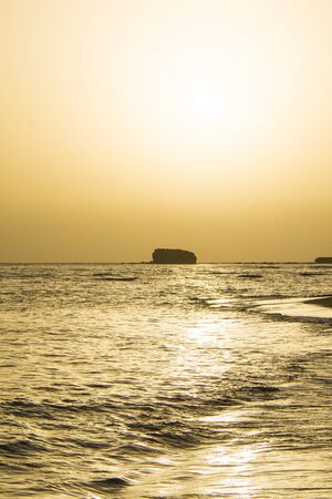 big rock in the sea, in the sunset, in the farの写真素材