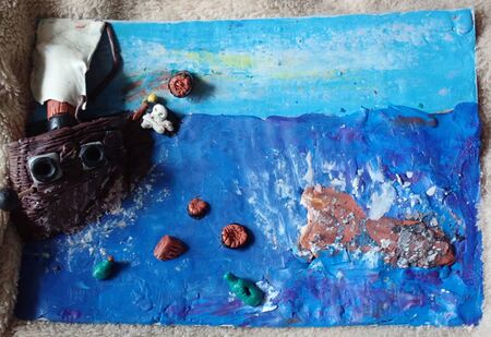 Plasticine picture with a sails pirate ship with items in the sea