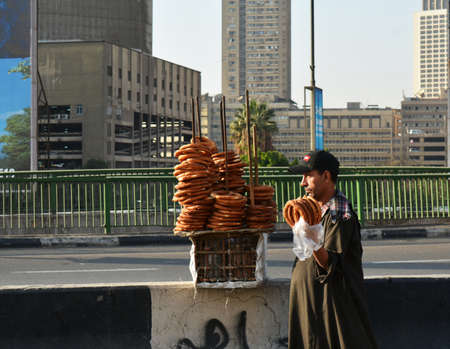 CAIRO/EGYPT - NOVEMBER 29, 2018: a man selling bagels on the street, next to the cars