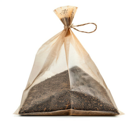 Full tea bag made of biodegradable material, containing loose leaf tea, tied with string, isolated on whiteの素材