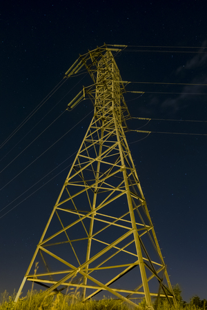 Unlighted Reliance power lines in the darkness. Template photo. The object in the countryside without lighting.の写真素材