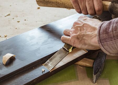Carpenter makes a chisel recess in the door unit