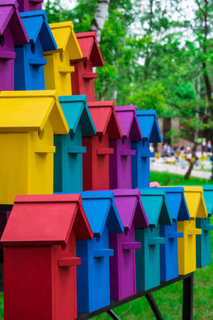 Rows of colorful birdhouses in the park. The new multicolored nesting boxes. Photo with limited depth of field.の写真素材