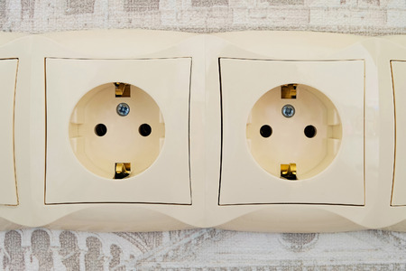 Detail of an electric socket block with two connection points. Interlocked electrical outlet on the wall.の写真素材