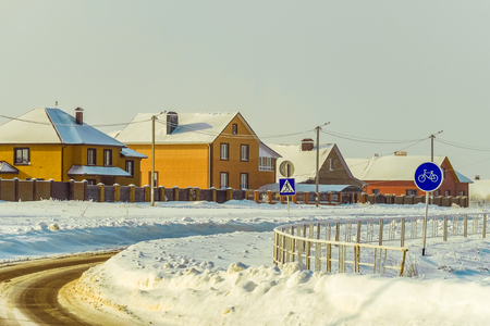Winter road in the village after snowfallの写真素材