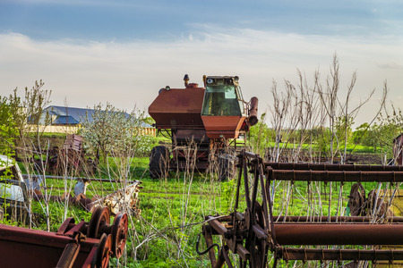 Lonely old combine harvester agricultural equipment in a landfill. Reaper harvester and abandoned outdated agricultural equipment.の写真素材