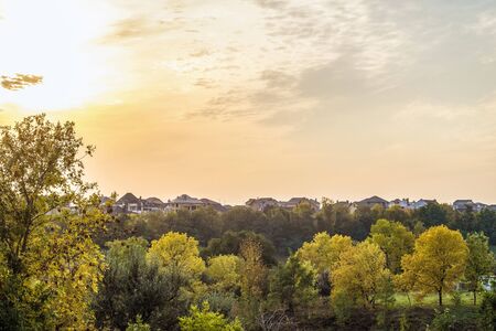 Evening sunset over the roofs of suburban houses. Autumn landscape in backlight sunlight. Belgorod Region, Russia.の写真素材