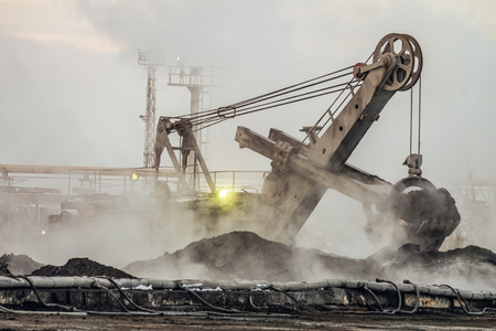 Big bucket excavator works in a outdoors dust dump. Industrial background.の写真素材