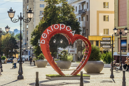 Belgorod, Russia - September 29, 2017: Street of the fiftieth anniversary of the Belgorod region. Pedestrian street in the old residential center of the city. Urban environment. Bench of love in the shape of a heart with flower pots.のeditorial素材