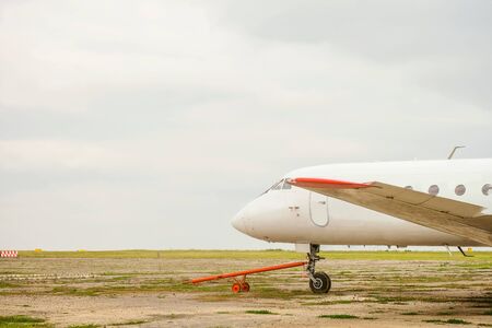 Old white passenger plane with a cruel hitch for transportation, standing in the parking lotの写真素材