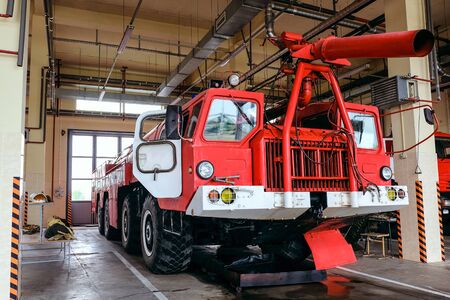 Large four-axle airfield fire truck standing in the garage of the fire boxの写真素材