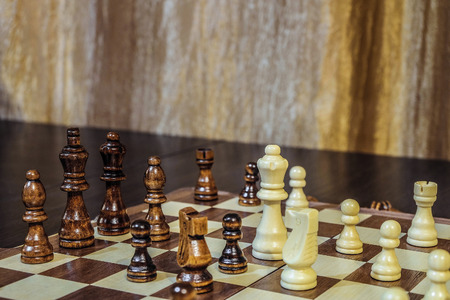Wooden chess Board and chess pieces in in the game. Limited depth of field.