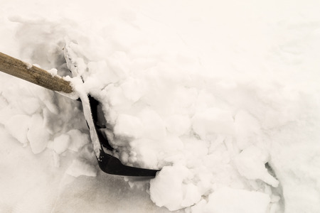 Clearing snow with a snow shovel. Shovel for cleaning the footpaths.の写真素材