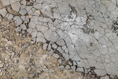 Surface of cracked and damaged outdoors cement-sand mortar leveling screed on concrete. Atmospheric...