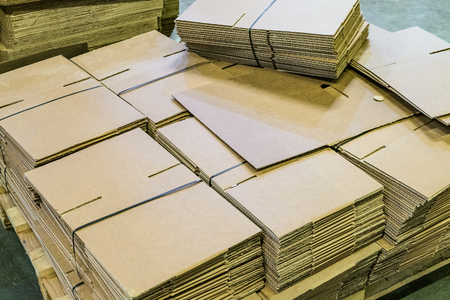 Corrugated cardboard sheets in piles for the production of cardboard boxesの写真素材