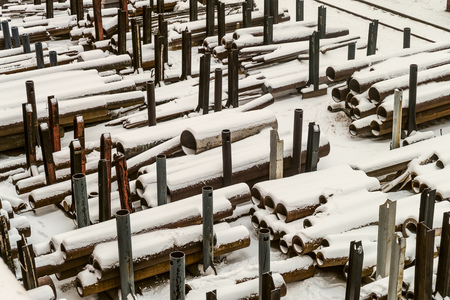 Outdoors industrial warehouse of finished steel pipes and metal products. Storage site at winter...