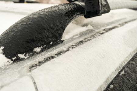 Detail of icy car body and a door after freezing rain. Unprotected outdoor transportation in winter weather conditions.の写真素材