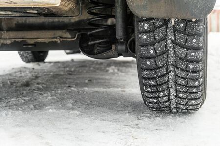 Wheel on a slippery snowy winter road. Car back wheel on a snowy winter.の写真素材
