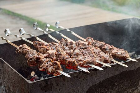 Meat skewered cooked on the grill. Hot tasty kebab in outdoors.の写真素材