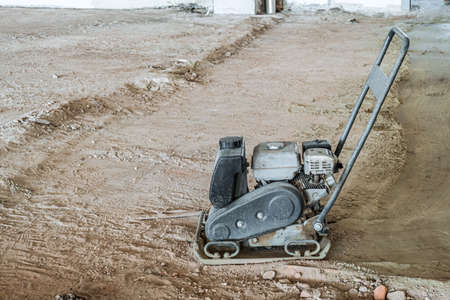 Tamping machine with vibratory plate. Vibratory rammer machine compresses the base soil for subsequent flooring. Side view.の写真素材