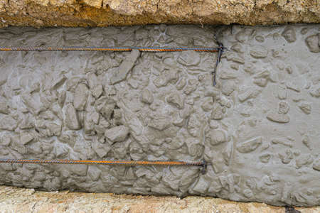 Freshly poured reinforced concrete in a trench. Construction of a monolithic strip foundation of a...