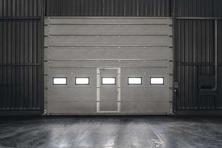 Overhead sectional gate inside an industrial building. Gray lift door.の写真素材