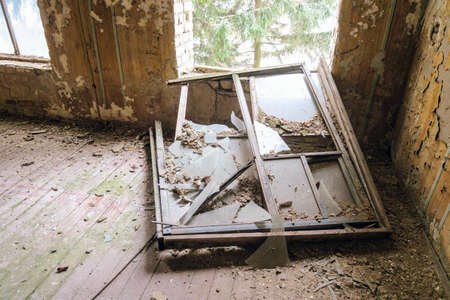 Old ruined tumbled out window inside of abandoned building