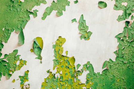 Peeling old green paint on the surface of the plastered wallの写真素材