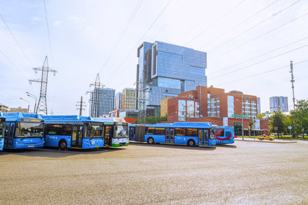 Moscow, Russia - July 21, 2021: Blue city buses near Water stadium station in moscow. Business center Vodny (Water) and hotel Okhotnik (Hunter) on Kronstadt Boulevard.のeditorial素材