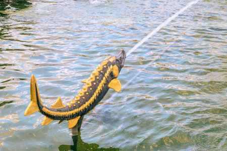 Moscow, Russia - July 21, 2021: Metal sculpture - sturgeon. Fountain "Stone flower" on VDNH park.のeditorial素材