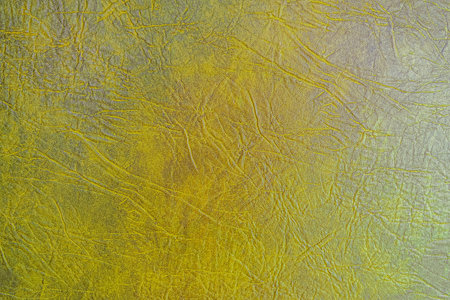Yellow-brown crumpled textured furniture upholstery faux leather texture. Embossing sample of leatherette.の写真素材