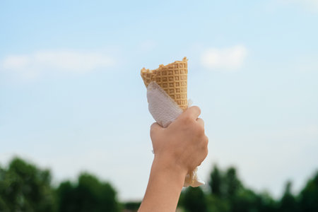 Waffle cone in a child's hand raised upの写真素材