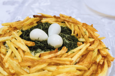Salad called wood grouse nest. Fried potatoes, boiled quail eggs and green dill in dish.