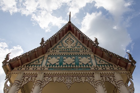 A pediment of monastery in Buddhist temple of Thailand under the blue sky 