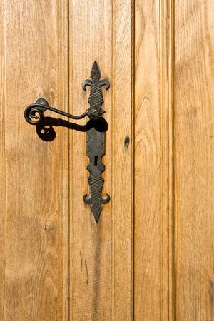 Ornate handle on a new wooden door.の写真素材