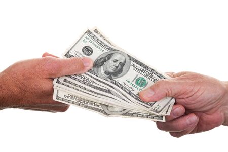 Two people passing a stack of one hundred dollar bills from hand to hand.の写真素材