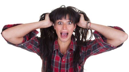 Pretty young woman pulling her hair and screaming in surprise and fear.の写真素材