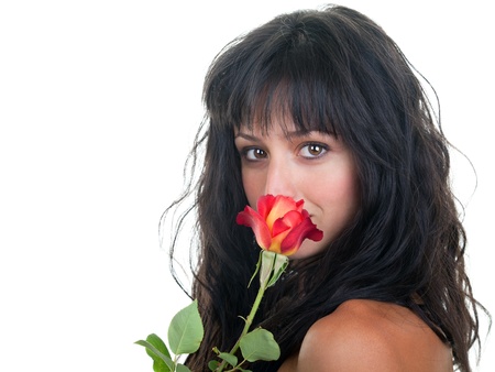 Beautiful young woman smelling a fresh red rose.の写真素材