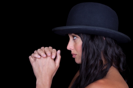 Attractive woman with a hat staring ahead in prayer.の写真素材
