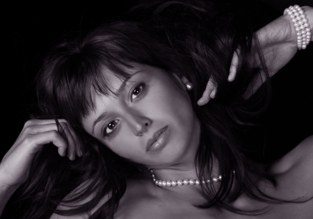 Beautiful young woman lying down wearing nothing but pearls.の写真素材