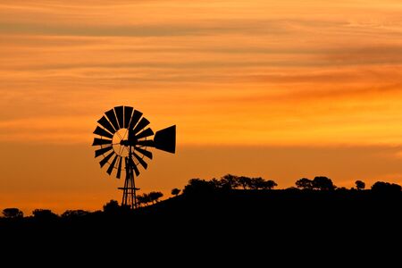 Sunrise with a windmill in Arizona.の写真素材