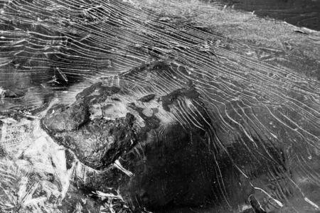Cracked ice pattern over a boulder in black and white の写真素材