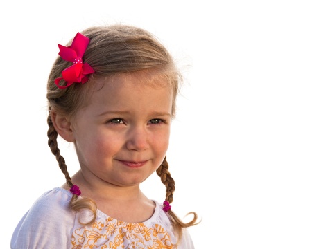 Cute little girl smiling shily, isolated on white background.の写真素材